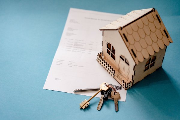 Real estate agreement with small house and keys on a table